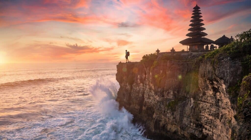 Uluwatu Temple silhouetted against a sunset sky on Samisha Holidays' Bali 8N/9D fixed departure tour package from Mumbai